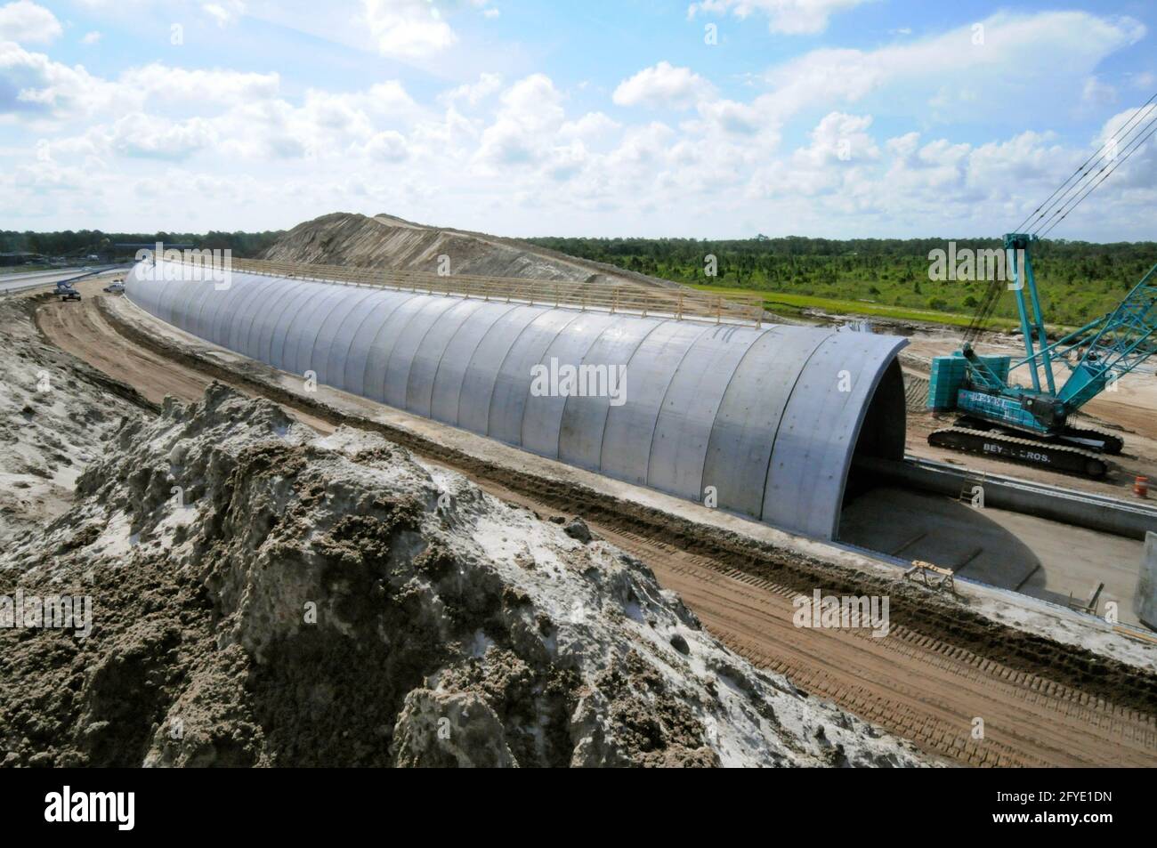 Cocoa, Brevard County. Florida USA. 27.Mai 2021. Die Bauunternehmen von BrightLine-Zügen haben die State Road 528 vorübergehend in den Norden ihres ursprünglichen Standorts verlegt, um Platz für einen überirdischen gebogenen Paneeltunnel zu schaffen. Nach der Fertigstellung wird die Betonkonstruktion mit Füllstoff bedeckt und an der alten Straße ausgerichtet. 125 Betonplatten wurden vor Ort gebaut und von Beyel Crane installiert. Kredit: Julian Leek/Alamy Live Nachrichten Stockfoto