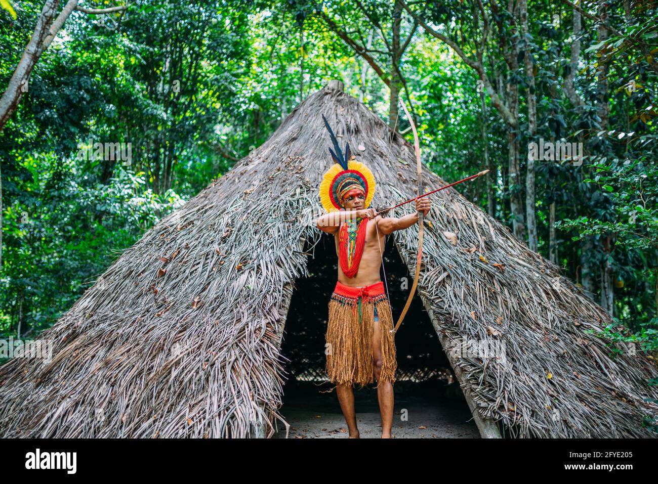Indianer aus dem Stamm der Pataxó mit Pfeil und Bogen. Brasilianischer  Inder mit Federkopfschmuck und Halskette Stockfotografie - Alamy