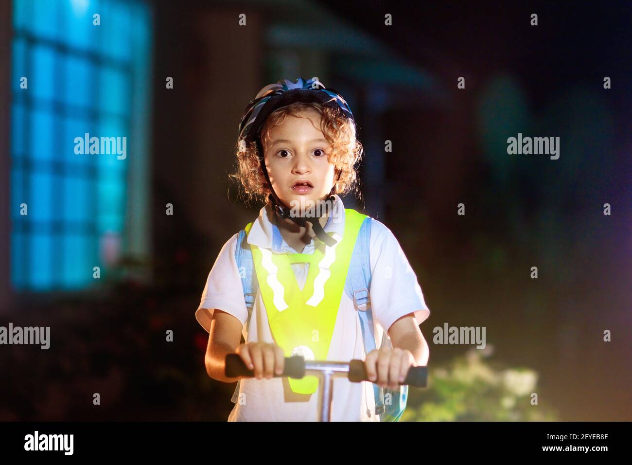 Kind in reflektierender Weste in der Dunkelheit. Sicherheit auf dunklen Straßen der Stadt für Schulkinder. Sicher nach Hause in der Nacht oder am Abend. Stockfoto