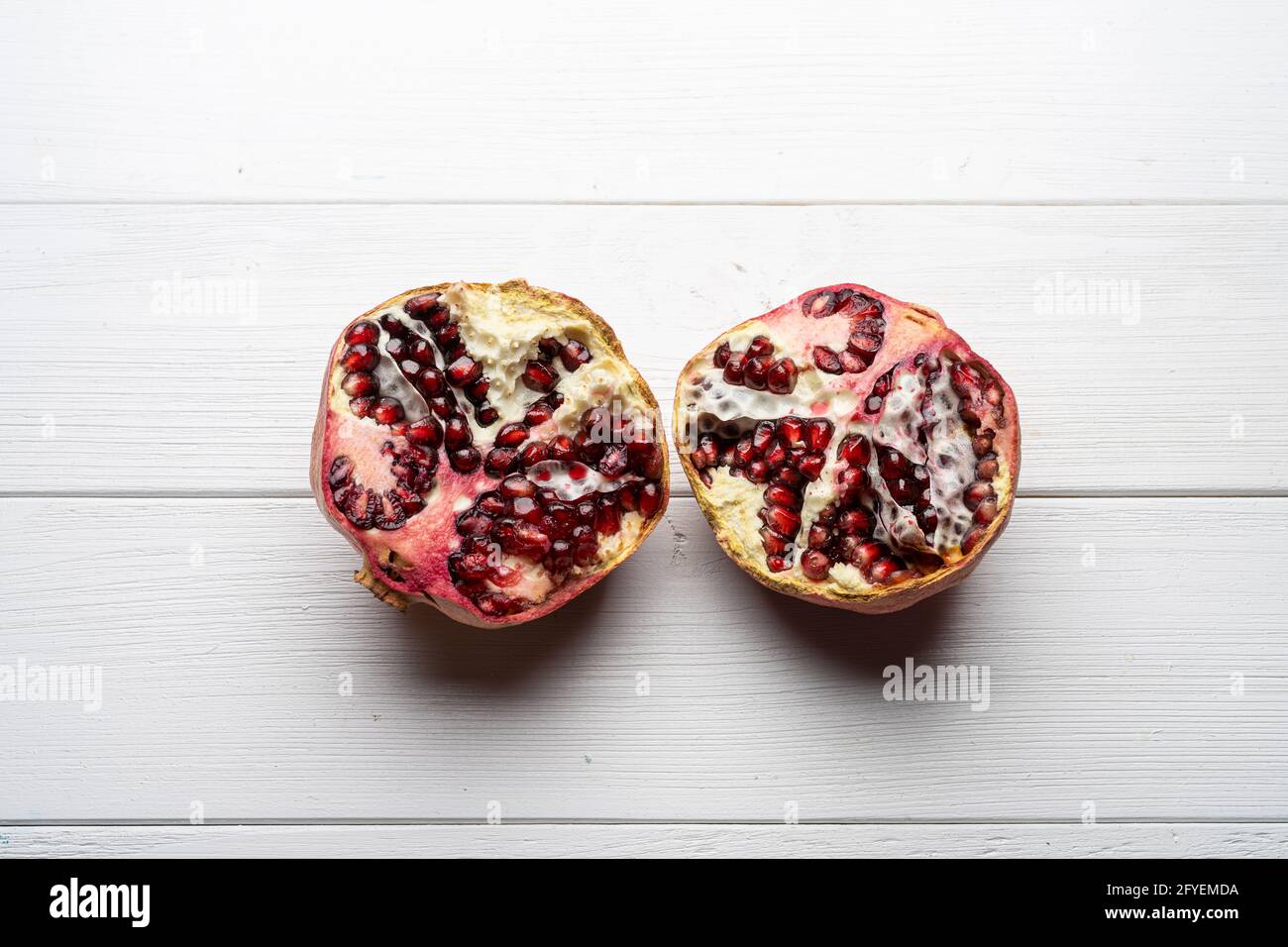 Ein Granatapfel auf einem weißen Holztisch Stockfoto