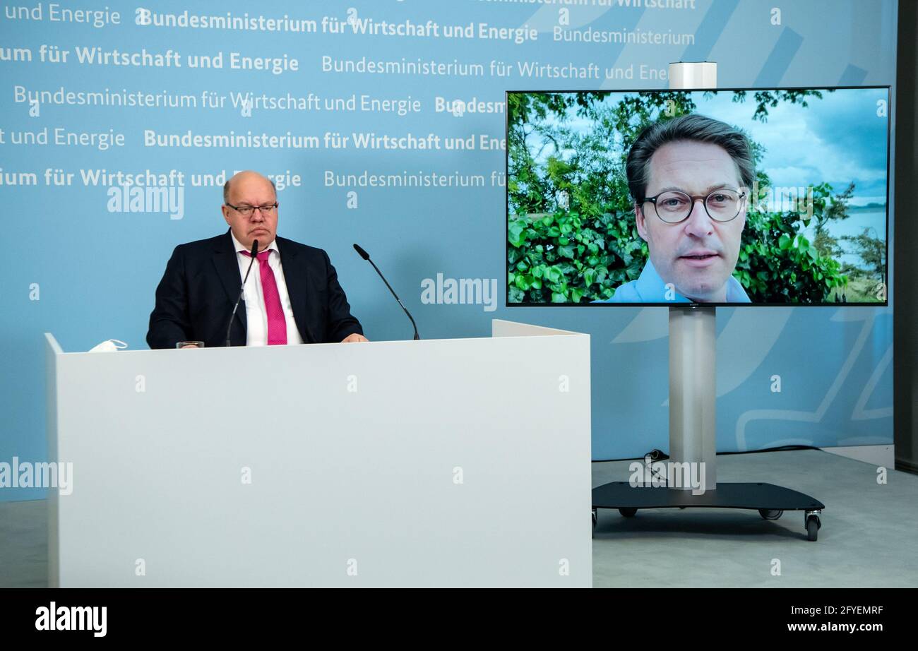 Berlin, Deutschland. Mai 2021. Peter Altmaier (l., CDU), Bundesminister für Wirtschaft und Energie, spricht auf einer virtuellen Pressekonferenz zur Projektauswahl für ein großes EU-Wasserstoffprojekt. Während der Pressekonferenz wird ein Grußwort von Andreas Scheuer (CSU), Bundesminister für Verkehr und digitale Infrastruktur, per Video abgespielt. Große Hoffnungen werden im Zuge der klimafreundlichen Transformation der Wirtschaft auf „grünen“ Wasserstoff gesetzt. Quelle: Bernd von Jutrczenka/dpa Pool/dpa/Alamy Live News Stockfoto