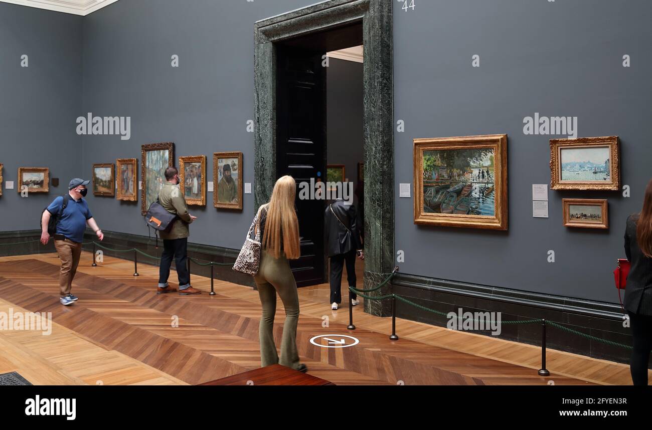 Besucher, die französische impressionistische Gemälde in der National Gallery, London, Großbritannien studieren Stockfoto