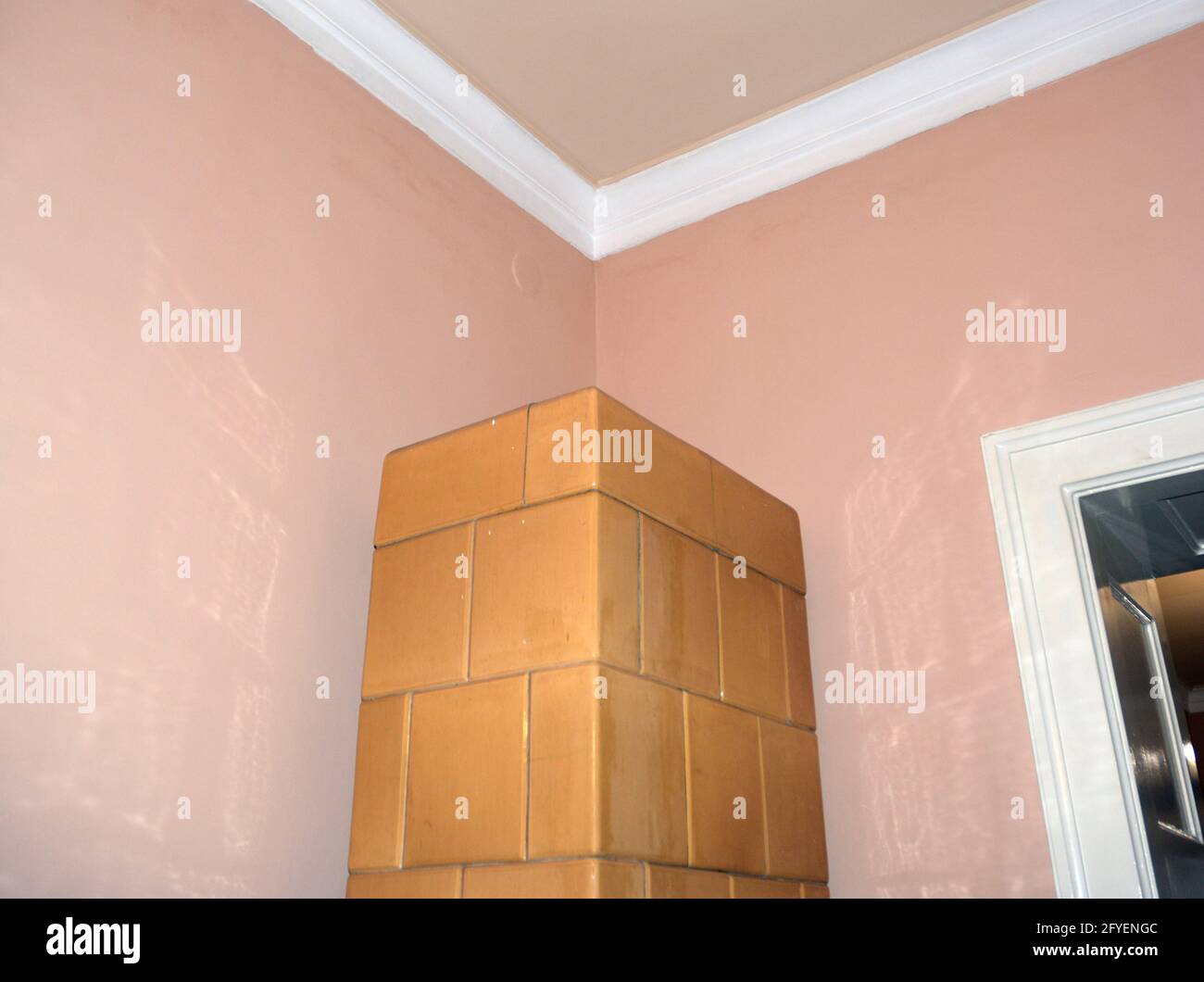 Eine gemauerte Heizung in einer Zimmerecke Stockfoto