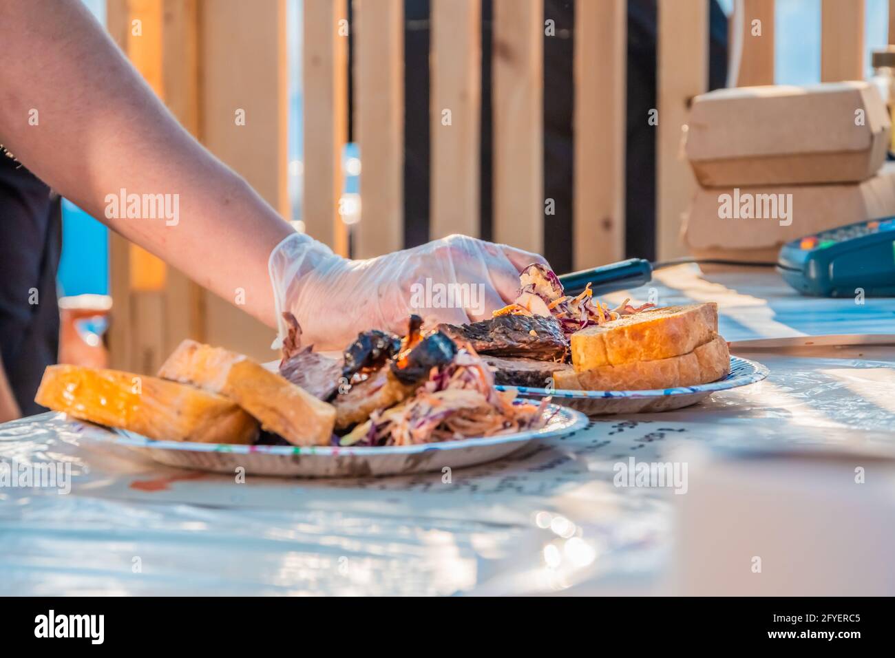Gegrilltes Fleisch, Salat und Brot auf Tellern an der Theke eines Straßenverkäufers. Food Festival im Stadtpark. Street Fast Food. Selektiver Fokus, sh Stockfoto