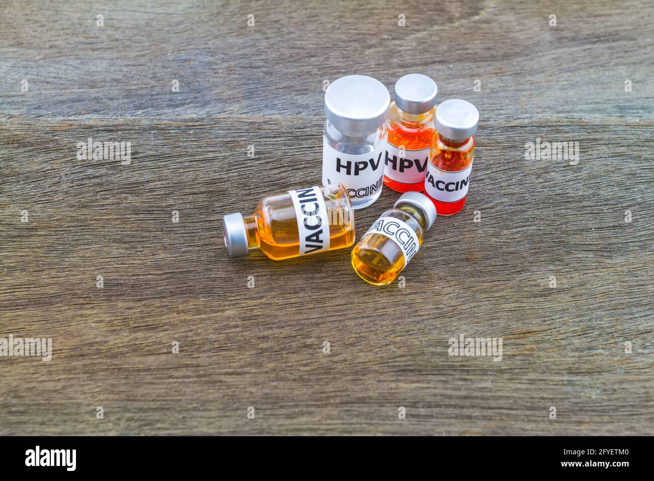 Flaschenimpfstoff des HPV-Impfstoffes (Human Papillomavirus) auf Holzgrund Stockfoto