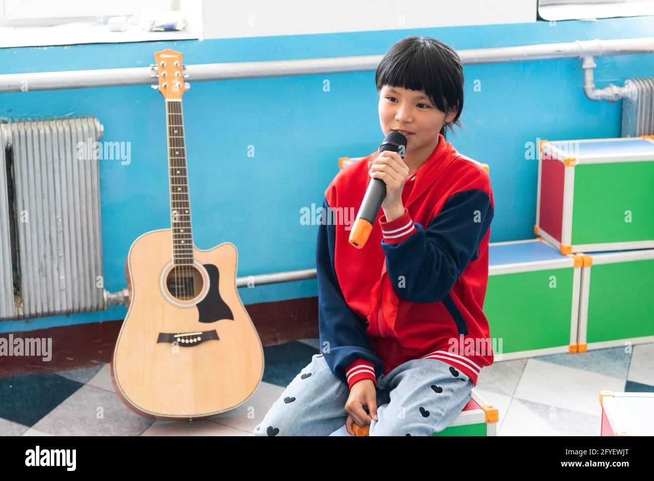 (210528) -- HARBIN, 28. Mai 2021 (Xinhua) -- EIN Kind singt während der Bandprobe an der zentralen Grundschule der Stadt Renmin in der Stadt Renmin in Anda, nordöstlich der Provinz Heilongjiang, am 27. Mai 2021. Li Ping und Zhang Yu sind Musiklehrer der zentralen Grundschule der Stadt Renmin. Im April 2019 wurde in der Schule ein Musikunterricht eingerichtet. „früher, als wir Musikunterricht gaben, stellten wir fest, dass einige Kinder sehr gut sangen, so dass wir ursprünglich die Absicht hatten, einen Musikkurs zu gründen, um Kinder, die Musik lieben, auszubilden und mehr ländlichen Studenten die Möglichkeit zu geben, Vokalmusik zu lernen Stockfoto