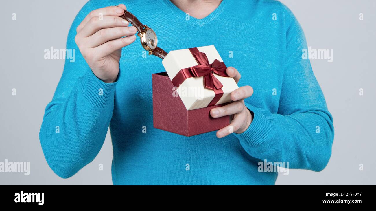 Armbanduhr in Geschenk-Box in der Hand des kurzbeschnittenen Mannes, Herrentag Stockfoto