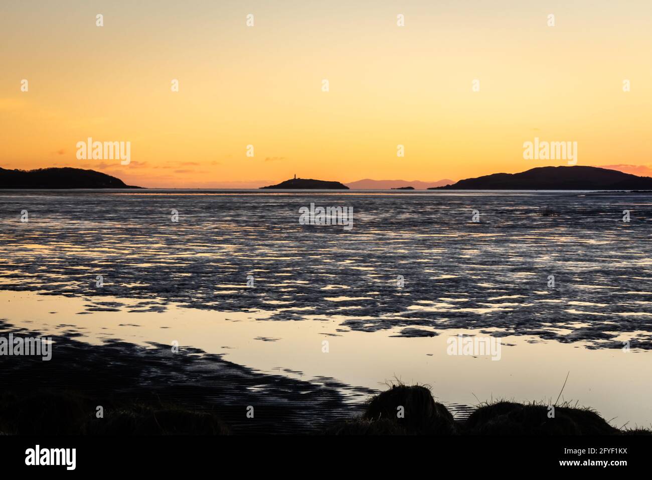 Goldener Winteruntergang über dem Wattenmeer der Kirkcudbright Bay und der Dee-Mündung bei Ebbe, mit Ross Island und der Insel man im Hintergrund, Dumfries Stockfoto