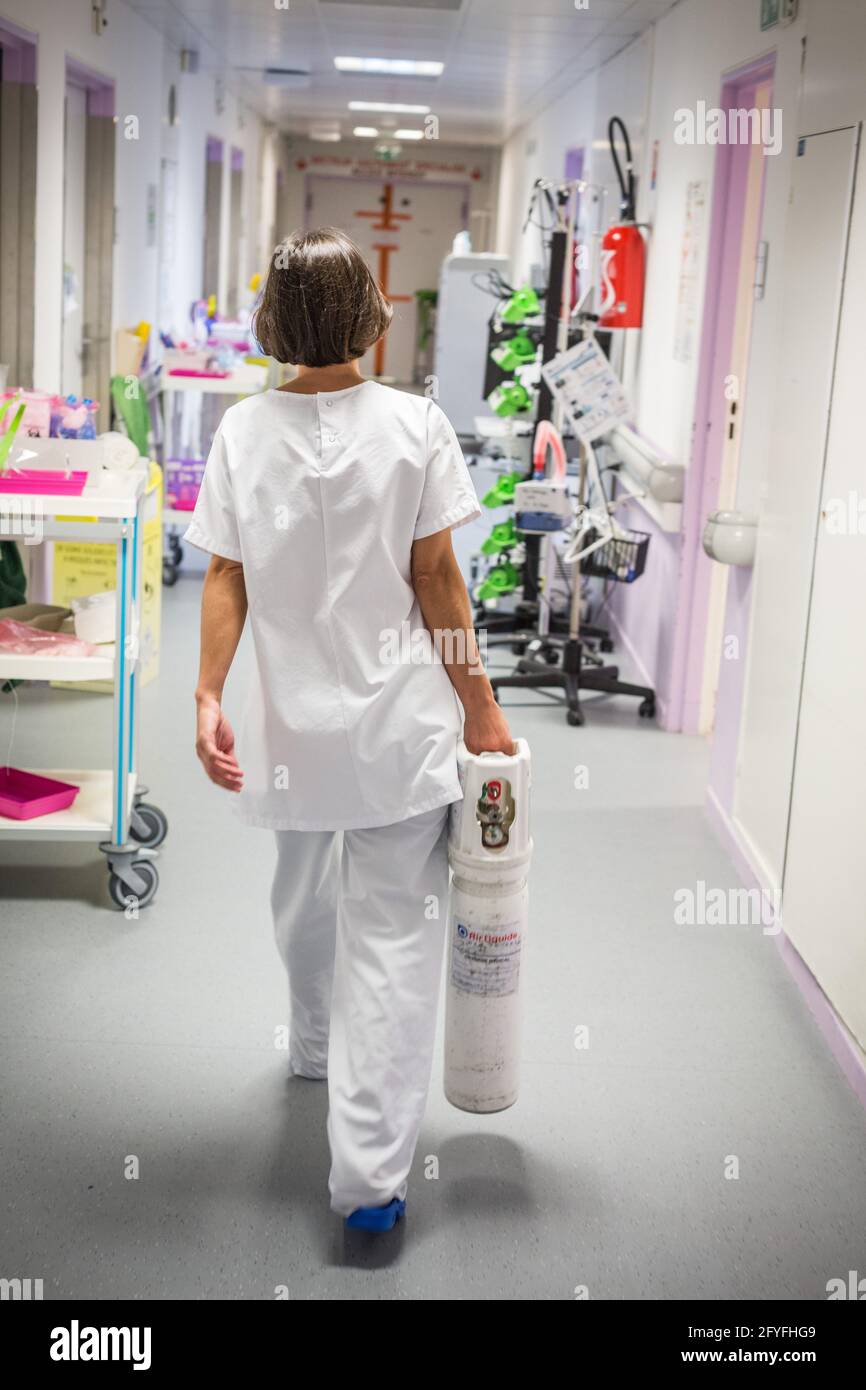 Eine Krankenschwester transportiert eine medizinische Sauerstoffflasche zu einer COVID-Krankenhausstation, CHU Limoges, Frankreich. Stockfoto