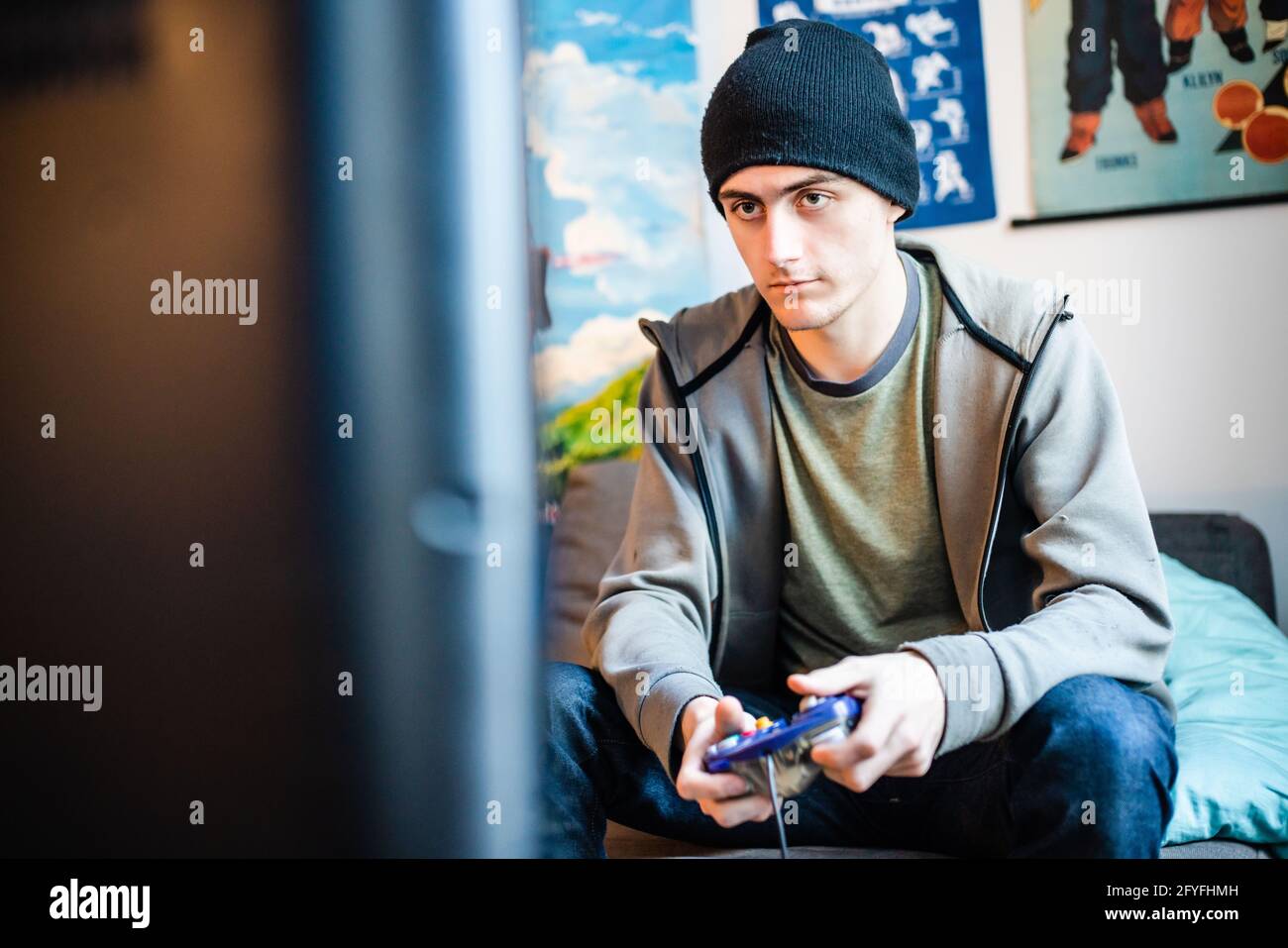 Junger Mann, der ein Videospiel mit einer Handsteuerung spielt, Frankreich. Stockfoto