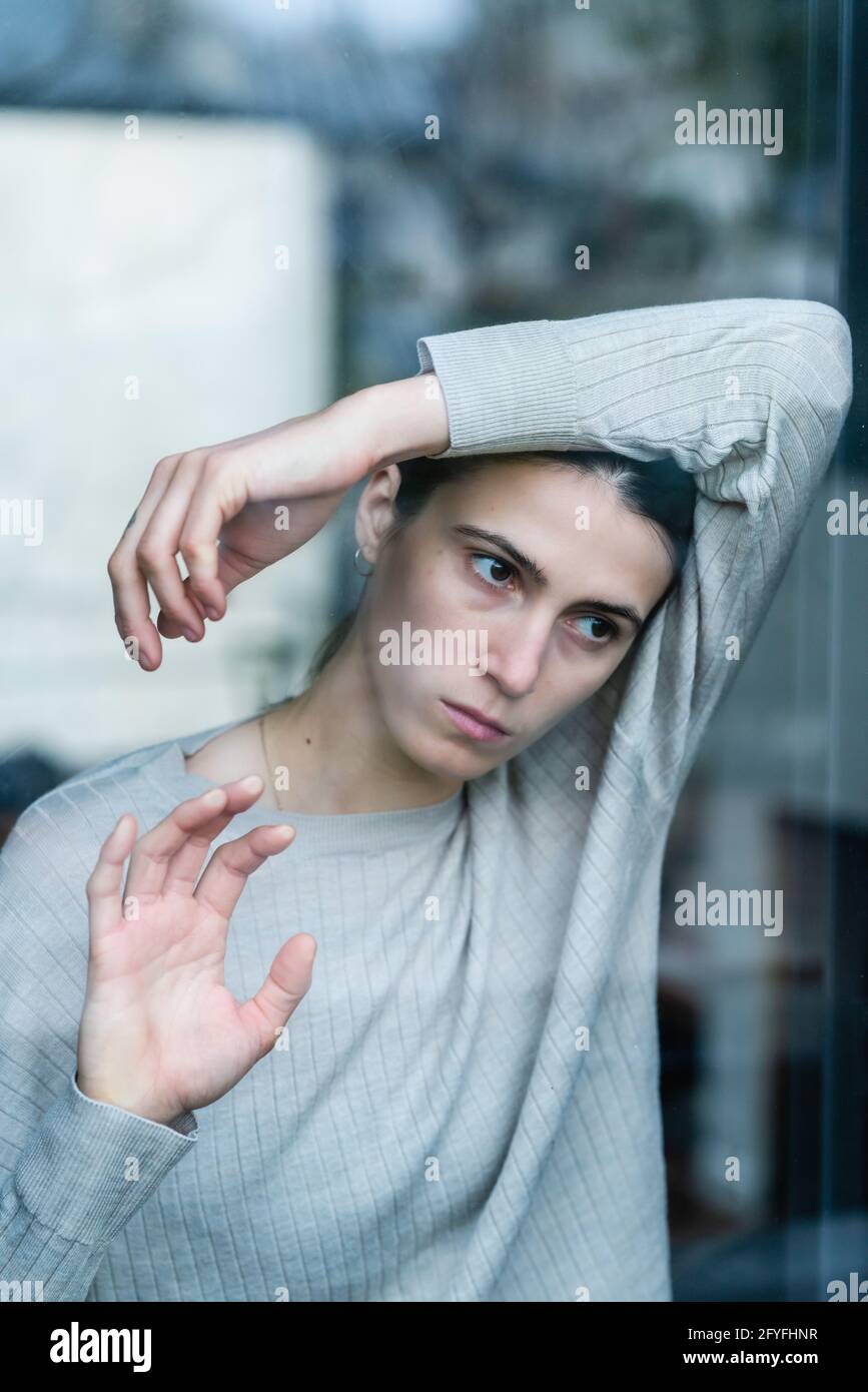 Junge Frau hinter einem Fenster. Stockfoto