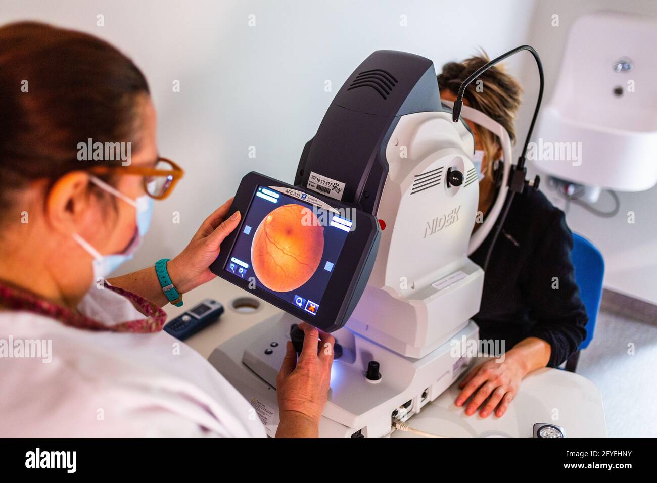 Frau, die Retinographie macht, ein diagnostischer Test, um ein Bild des Fundus oder der Netzhaut zu erhalten und Krankheiten zu erkennen, die die Netzhaut betreffen, wie altersbedingte Stockfoto