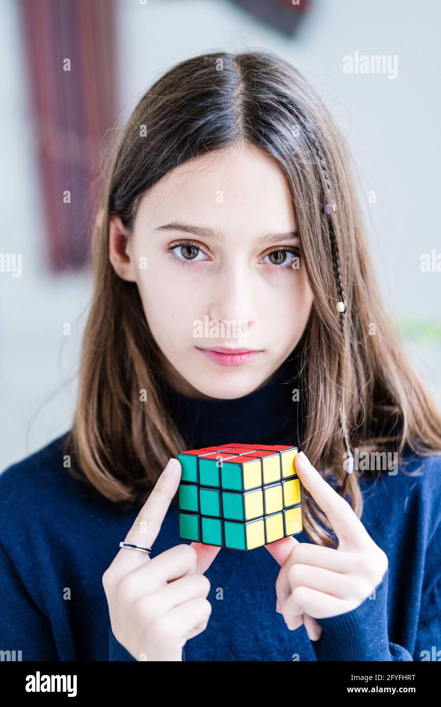 Junges Mädchen, das mit einem Rubik's Cube® spielt. Stockfoto