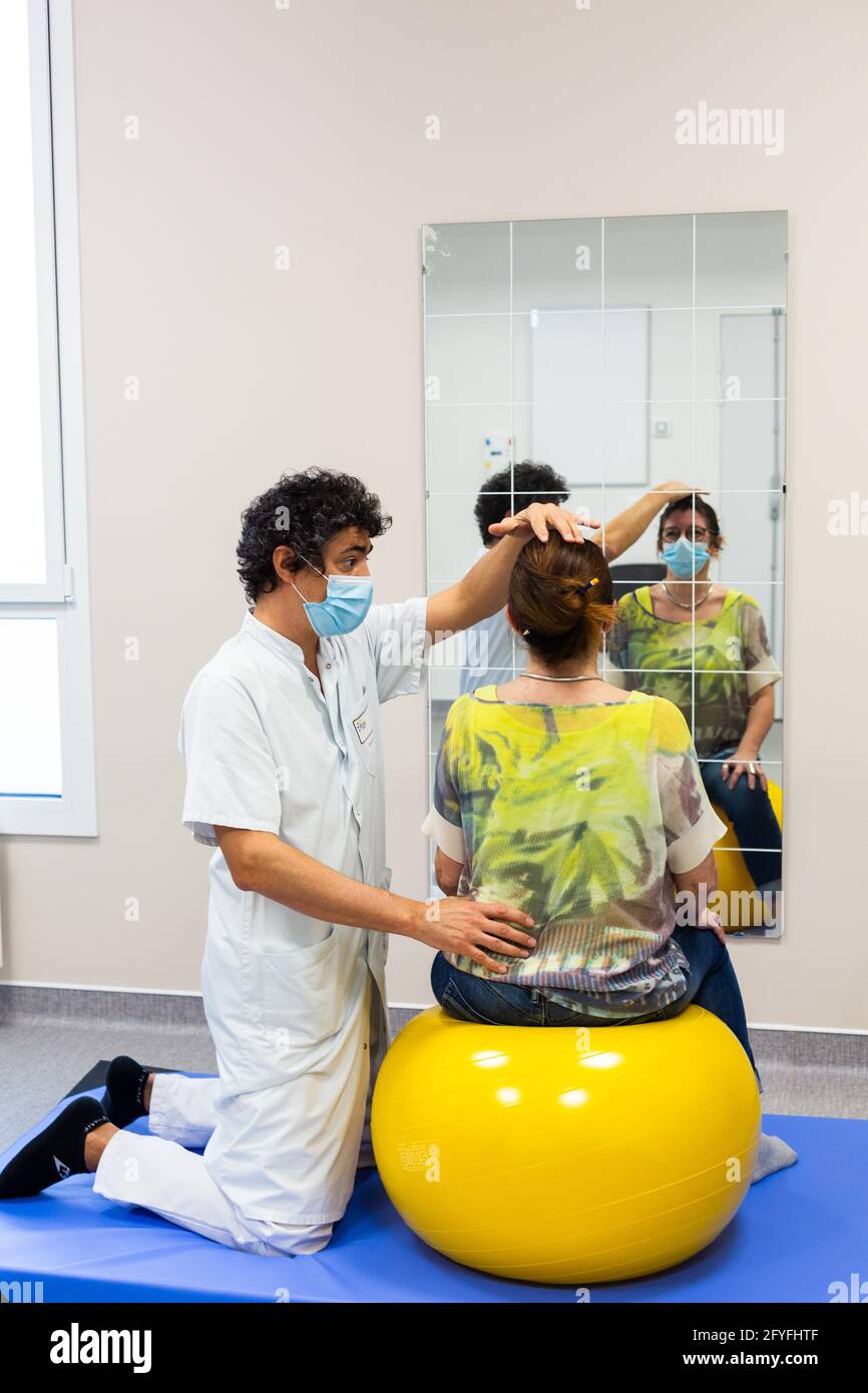 Muskelstärkung mit einem Physiotherapeuten zur Linderung von Schmerzen im unteren Rücken mit einem Reha-Ball (Swiss Ball). Krankenhaus Limoges, Frankreich. Stockfoto