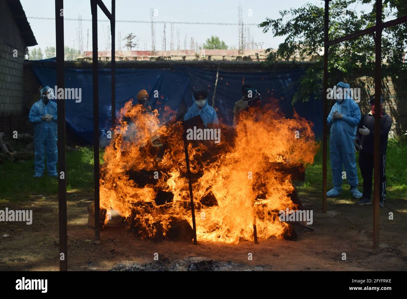 Srinagar, Kaschmir. Mai 2021. Verwandte und Freiwillige schauen zu, während ein Opfer von Covid-19 auf einem Verbrennungsgrund eingeäschert wird. Kredit: Majority World CIC/Alamy Live Nachrichten Gutschrift: Majority World CIC/Alamy Live Nachrichten Stockfoto