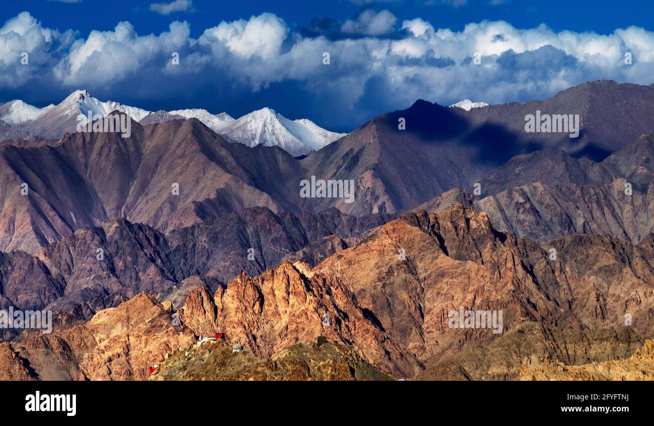 Panoramische felsige Landschaft von Leh City mit Eisspitzen im Hintergrund, blauer Himmel mit Wolken, Ladakh, Jammu und Kaschmir, Indien Stockfoto