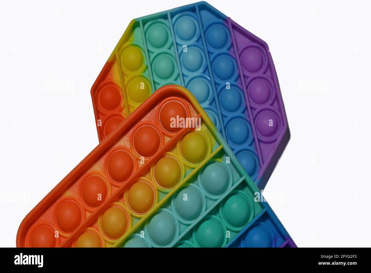 Zwei bunte Pop-it-Spielzeuge in Form von Sechseck und Rechteck Nahaufnahme. Isolieren. Stockfoto