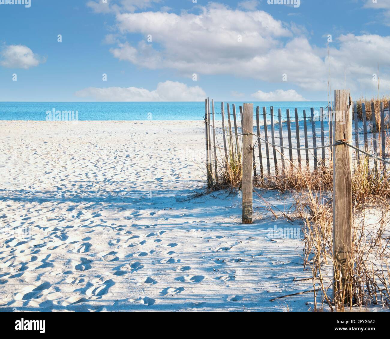 Florida Strandszene mit Strandzaun und Pfosten. Blauer Himmel und weiße Wolken. Stockfoto