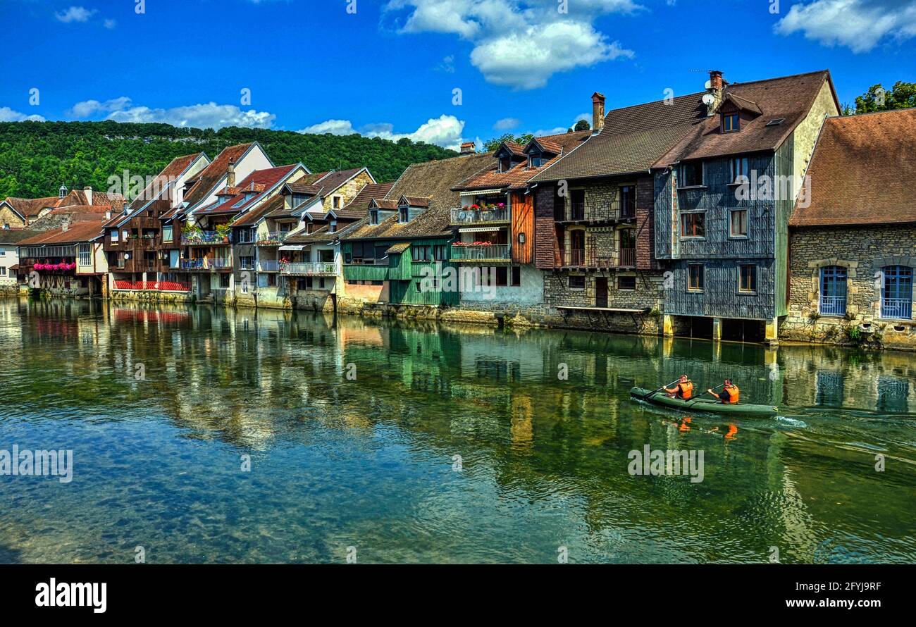 Kanufahrt entlang des Flusses Loue, der von den charakteristischen Häusern überblickt wird. Stadt Ornans im Département Doubs, Burgund-Franche-Comte Stockfoto