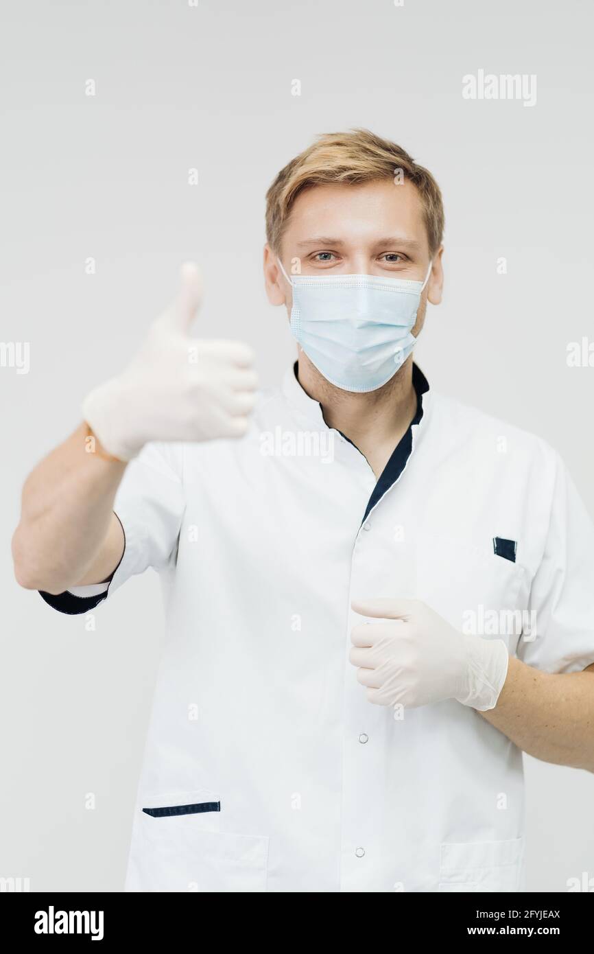 Attraktive männliche Arzt zeigen Daumen nach oben Hand Zeichen isoliert auf weißem Hintergrund, Modell ist ein kaukasischer Mann Stockfoto