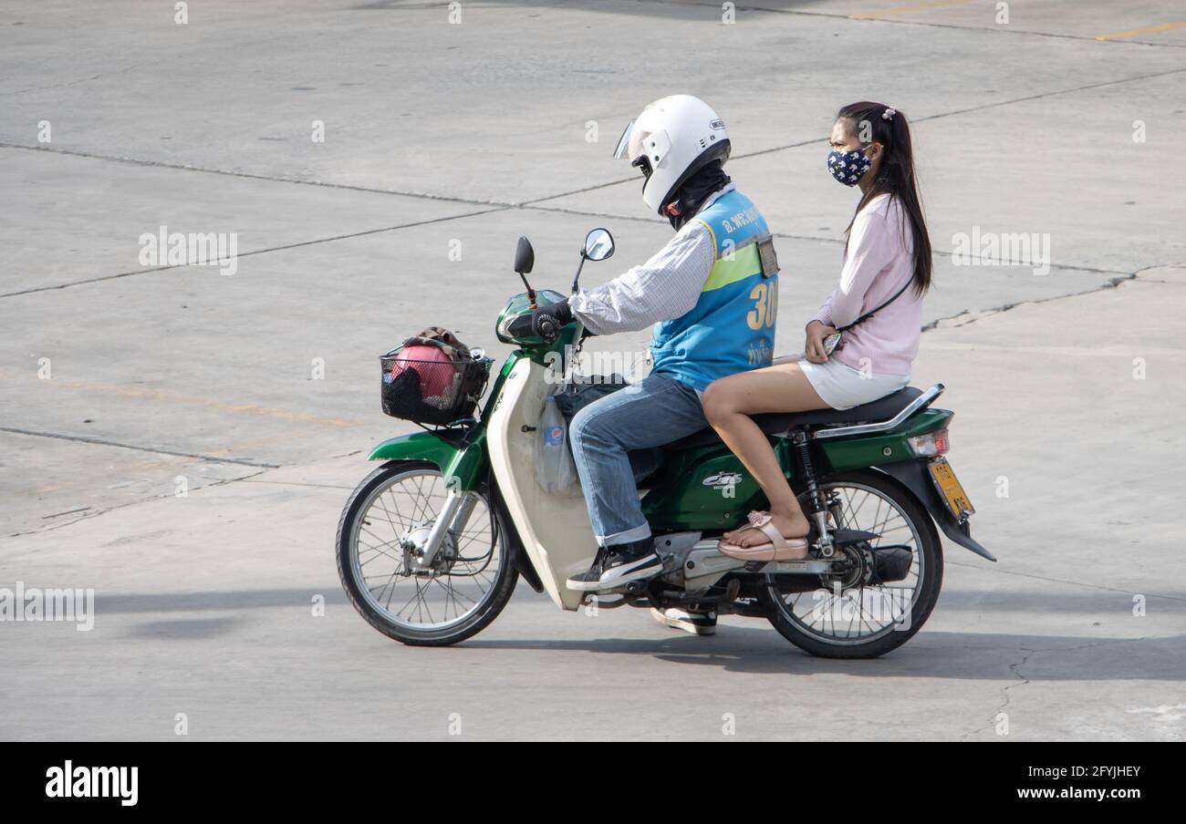 SAMUT PRAKAN, THAILAND, JULI 27 2020, EIN Taxifahrer auf einem Motorrad fährt mit einer Frau. Der mototaxi-Fahrer trägt einen Beifahrer. Stockfoto