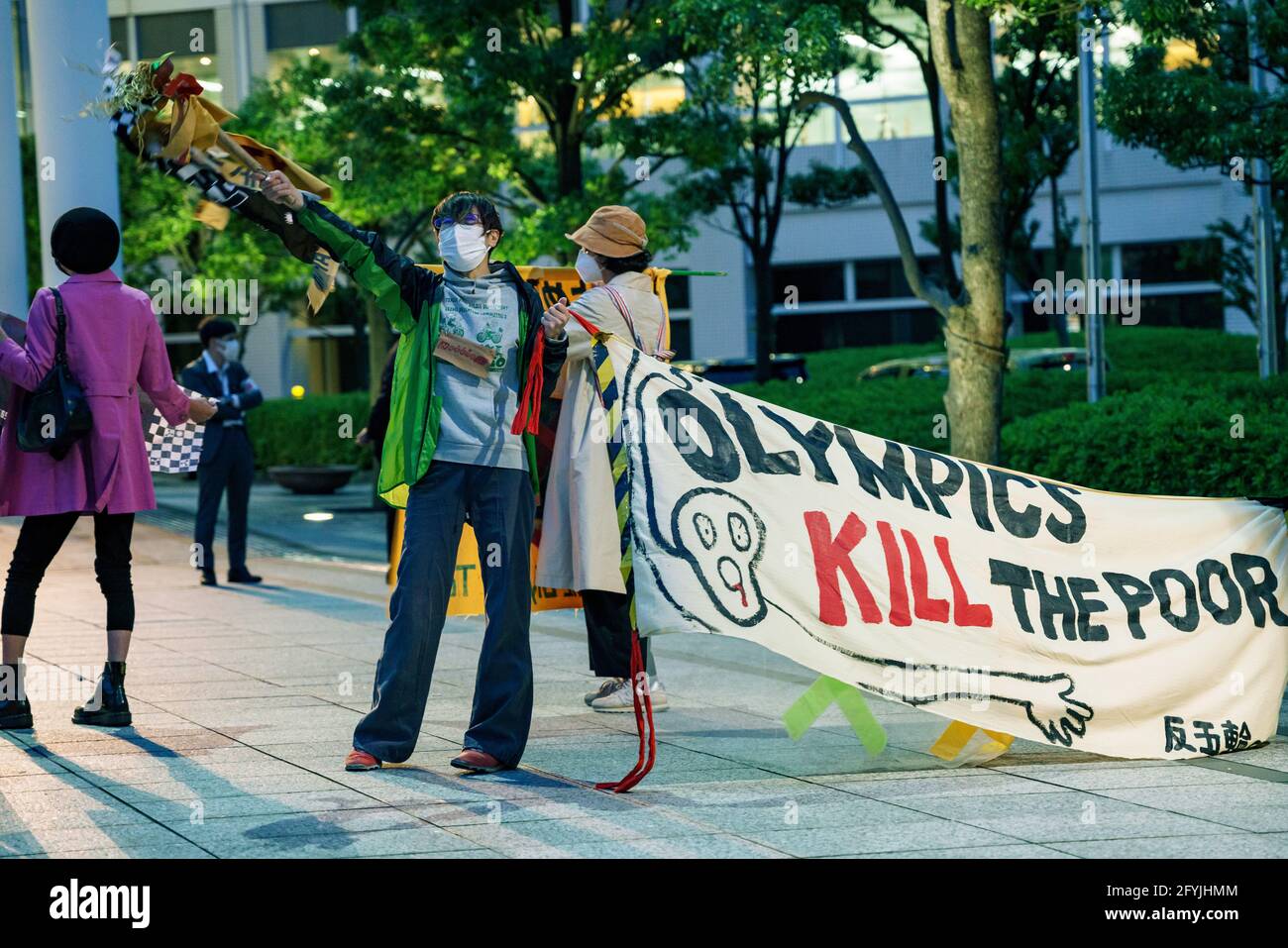 29. Mai 2021: Protestierende Wellen Band mit mehreren Sprachen geschrieben, während ein "Olympics Kill the Poor" Zeichen während des Protests gegen die Olympischen Spiele 2020/2021 in Tokio Stockfoto