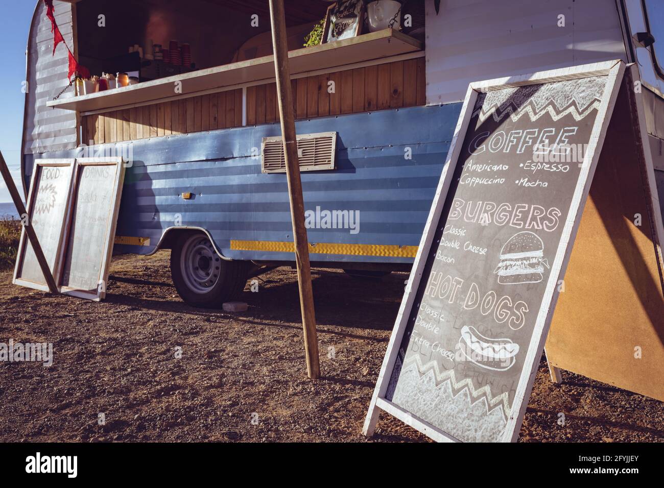 Allgemeine Ansicht von Food Truck und Menuboard am Meer An einem sonnigen Tag Stockfoto