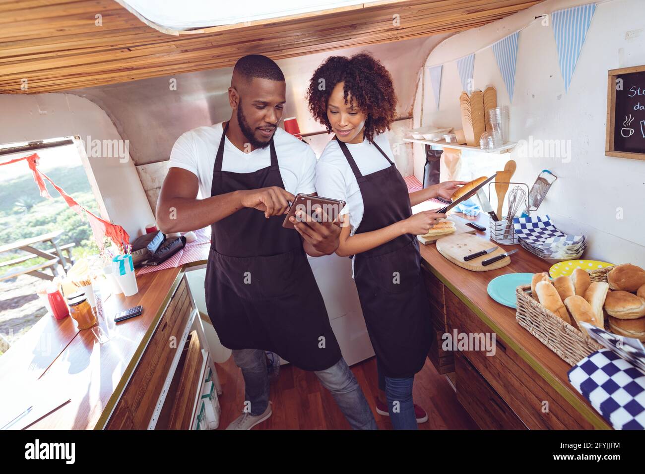 Diverse paar hinter dem Counter mit Tablet in Food Truck Stockfoto