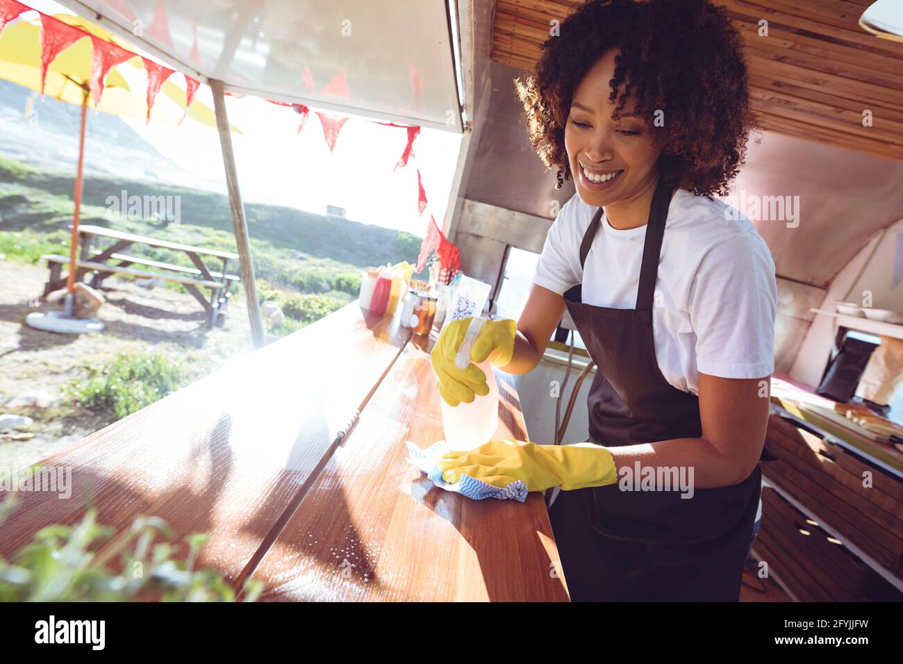 Lächelnde Mischling Frau Reinigung Zähler in Food Truck Stockfoto