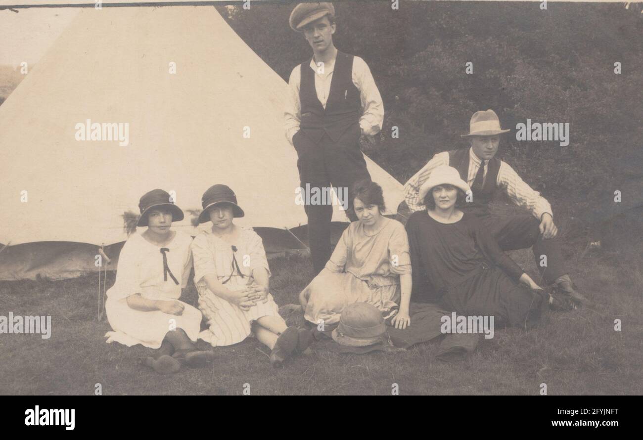 Vintage britische Postkarte, die eine Gruppe modischer Männer und Frauen zeigt, die campen. Stockfoto