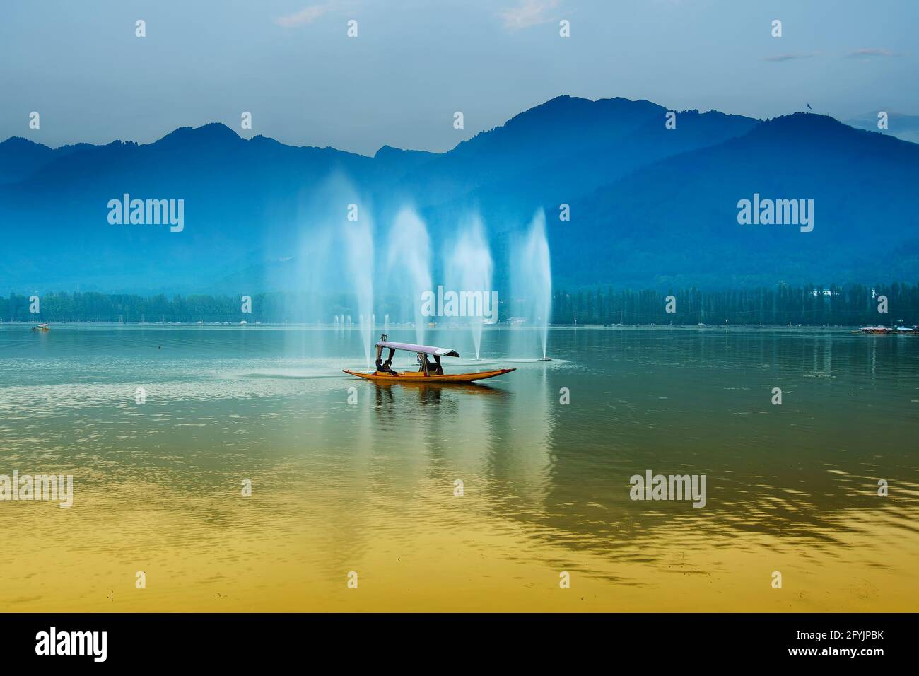 Spiegelung der Himalaya-Berge am Dal Lake, Srinagar, Jammu und Kaschmir, Indien. Hausboote schwimmen in der Nähe von Brunnen auf dem See am späten Nachmittag. Stockfoto