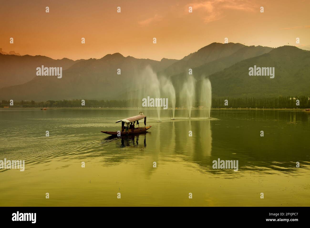 Spiegelung der Himalaya-Berge am Dal Lake, Srinagar, Jammu und Kaschmir, Indien. Hausboote schwimmen in der Nähe von Brunnen auf dem See am späten Nachmittag. Stockfoto