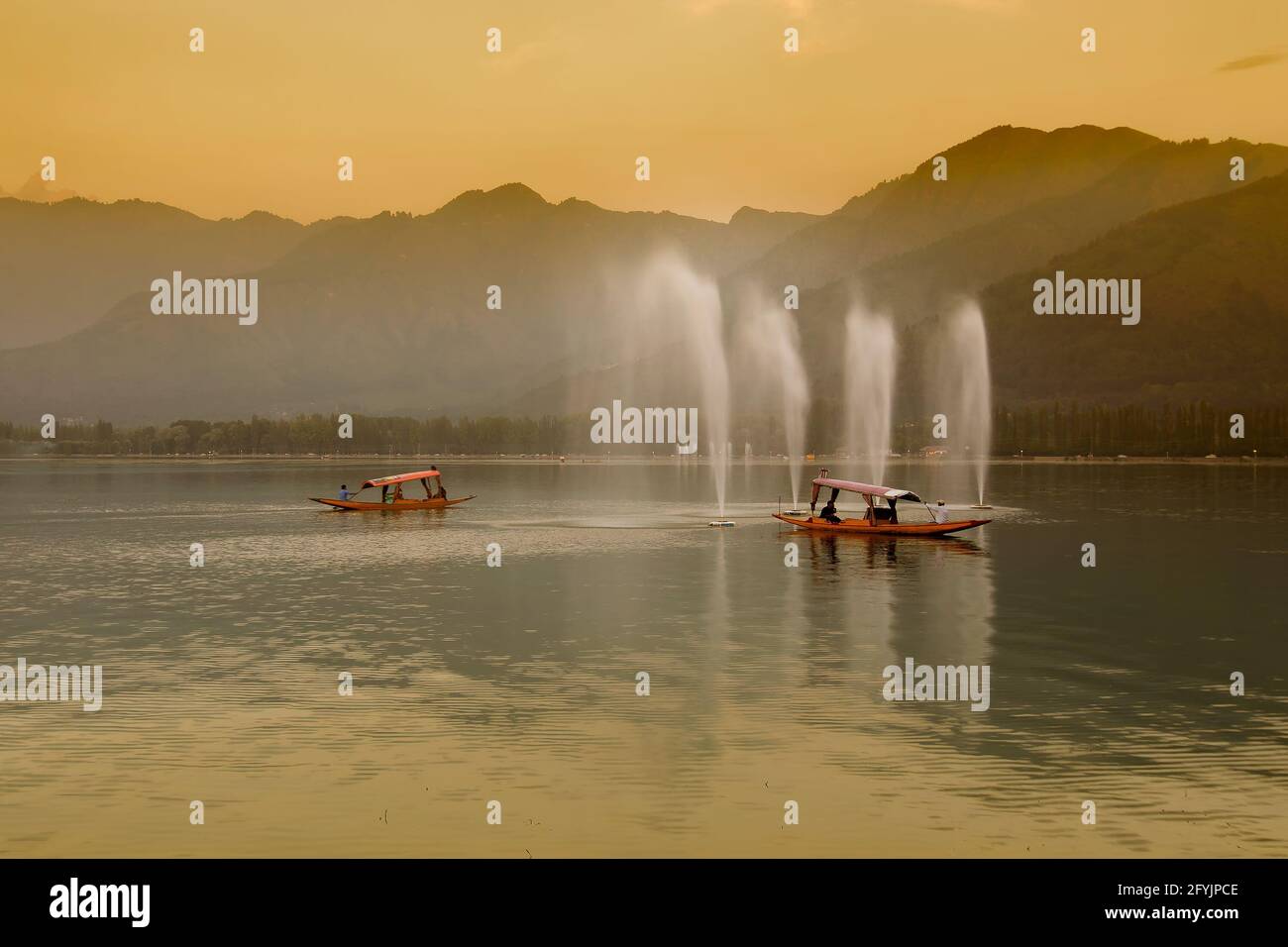 Spiegelung der Himalaya-Berge am Dal Lake, Srinagar, Jammu und Kaschmir, Indien. Hausboote schwimmen in der Nähe von Brunnen auf dem See am späten Nachmittag. Stockfoto