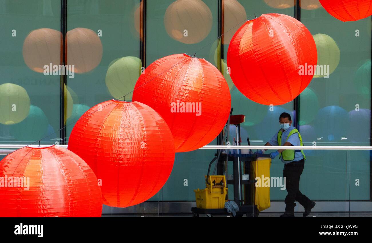 Eine Reinigungsperson rollt einen Wagen an Papierlaternen im Einkaufszentrum Santa Monica Place, Santa Monica, Kalifornien, USA, vorbei Stockfoto