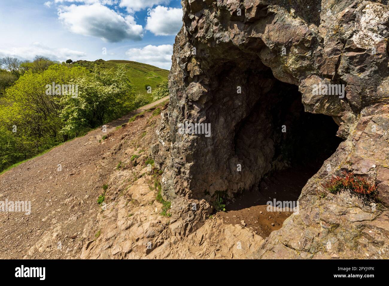 Der Eingang zur Clutter’s Cave in den Malvern Hills mit British Camp im Hintergrund, Worcestershire, England Stockfoto