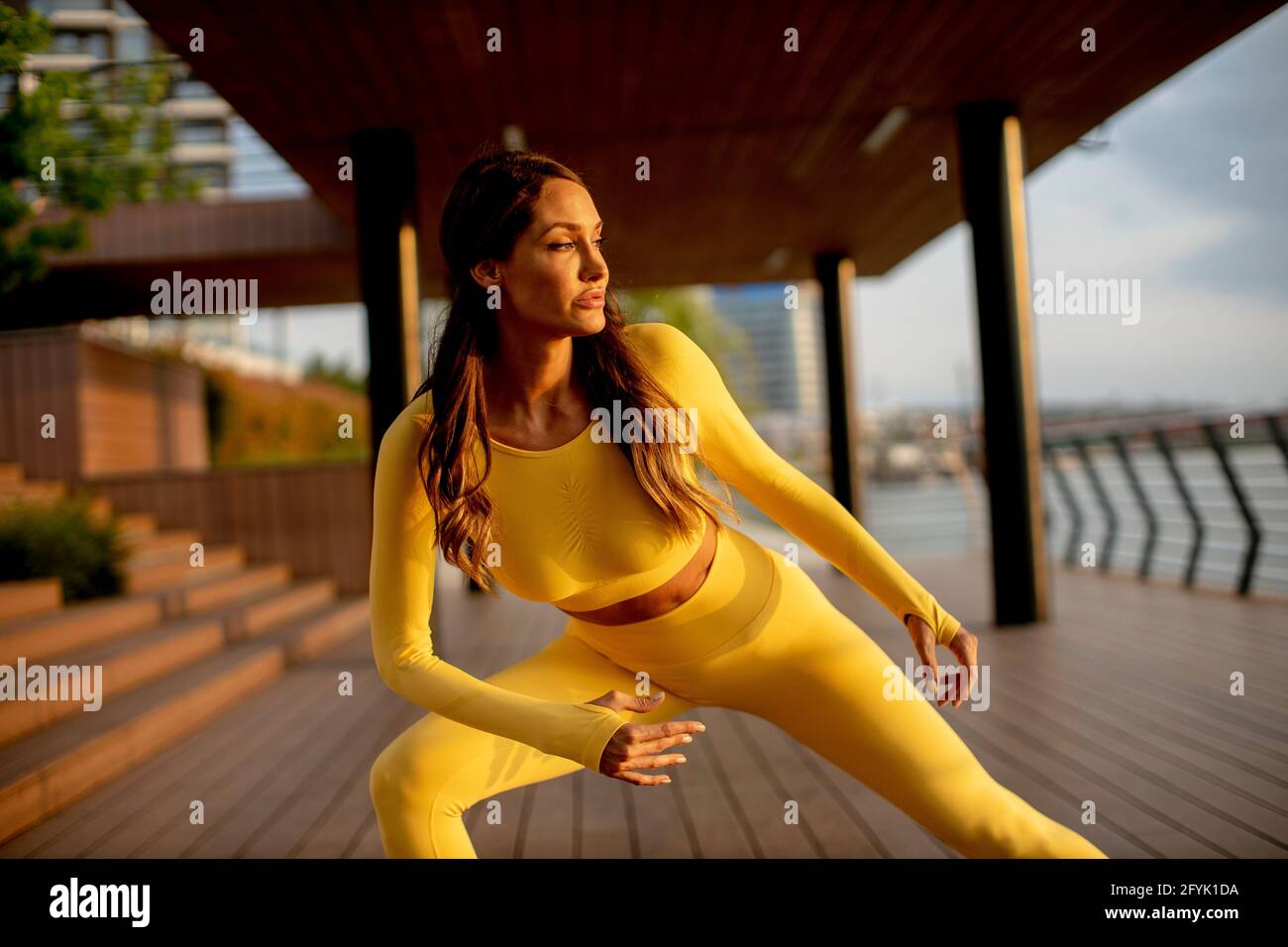 Schöne junge Frau, die sich am Flussufer ausdehnt Stockfoto