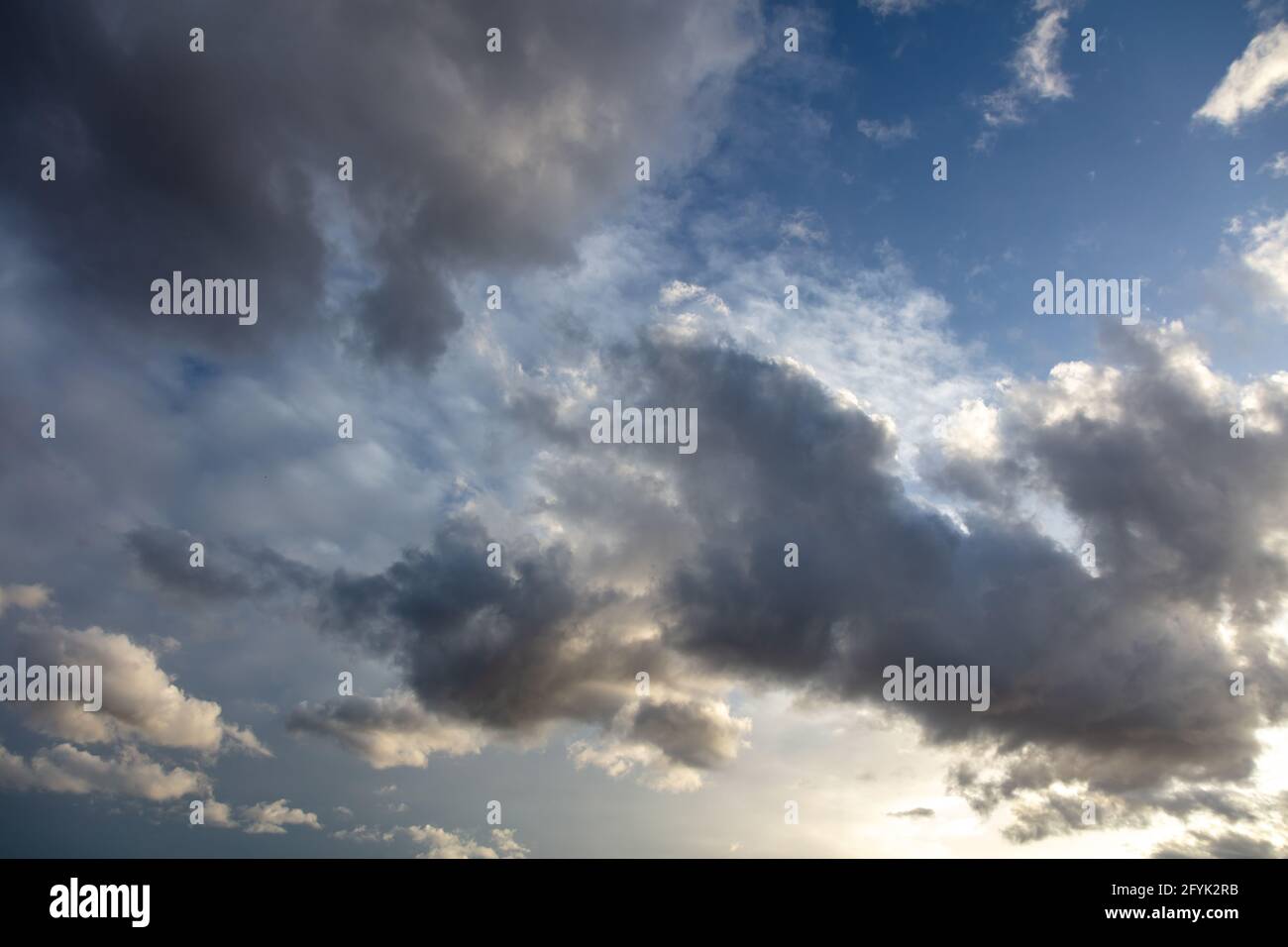 Überdecktes Konzept. Schwere dunkle Regenwolken auf blauem Himmel Hintergrund Raum. Wolkenlandschaft farbenfroher Horizont, abstrakt, Sonnenstrahlen, die den Himmel färben, machen ihn zu einer id Stockfoto