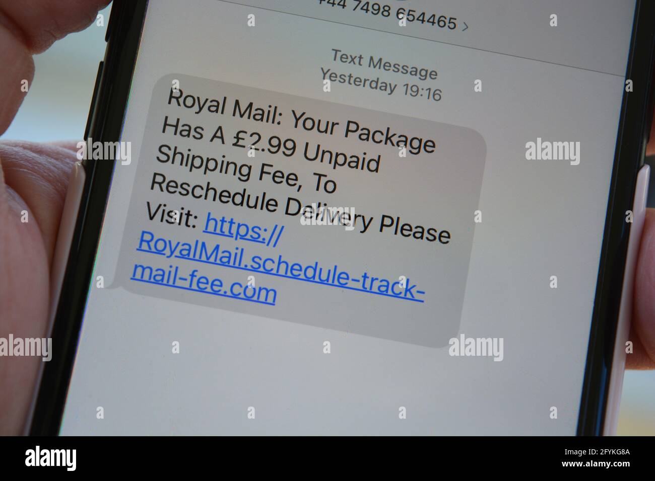 Phishing-Text, Nachricht auf dem Bildschirm, in der angegeben wird, dass das Paket eine unbezahlte Versandgebühr enthält, und der Empfänger muss auf den Link klicken, um die Lieferung neu zu planen Stockfoto