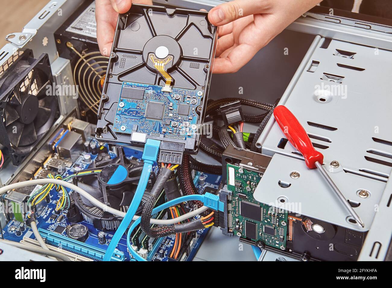 Entfernen der Computerfestplatte aus der Systemeinheit, um sie durch eine neue zu ersetzen. Stockfoto