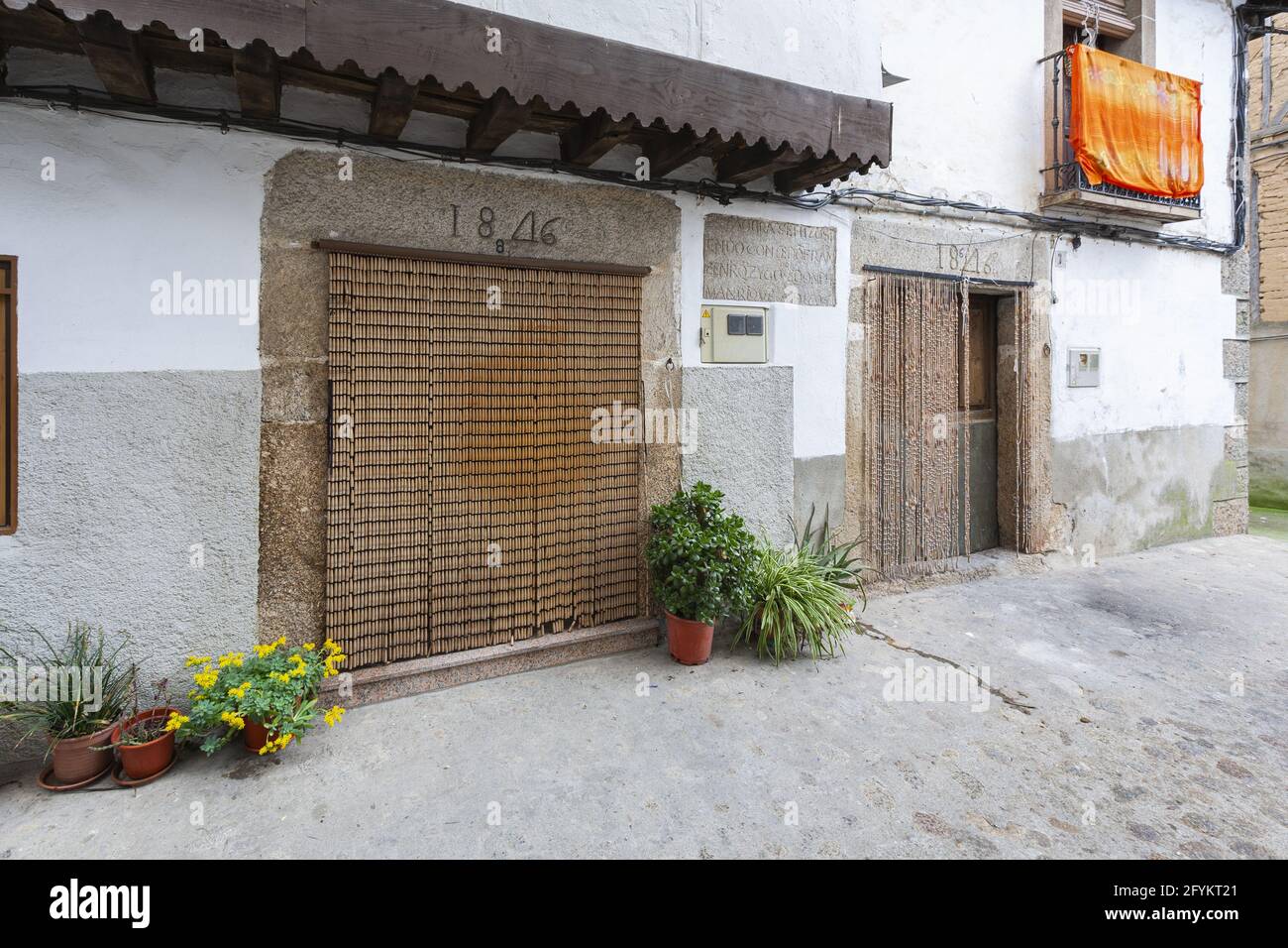 VILLANUEVA DE LA VERA, SPANIEN - 08. März 2021: Villanueva de la Vera, Spanien - 08. März 2021: Tür eines Hauses mit den typischen Vorhängen, um die e zu verhindern Stockfoto