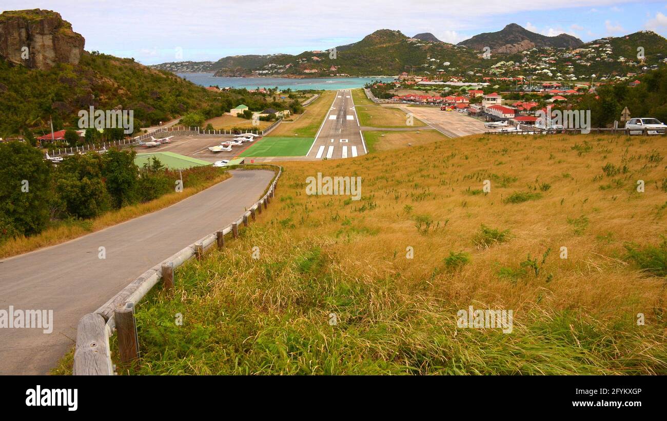 ST BARTHELEMY; ST. BARTH'S AIRPORT; BERÜHMTER GUSTAF III AIRPORT, AUF DEM FLUGZEUGE BEI DER LANDUNG SEHR NAHE AN DER STRASSE FLIEGEN Stockfoto