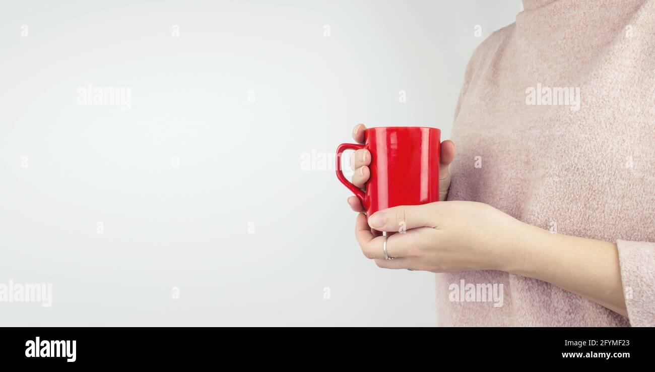 Junge Frau hält Kaffeetasse in der Hand. Konzept „Guten Morgen“ Stockfoto