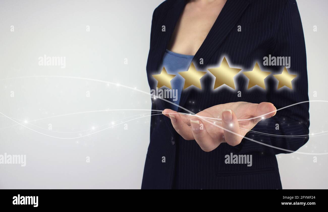 Customer Experience Konzept. Hand halten digitales Hologramm fünf-Sterne-Symbol auf grauem Hintergrund. Der Beste, Exzellente Service Stockfoto
