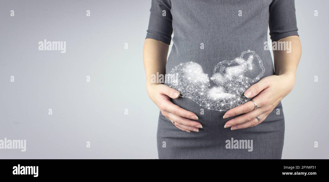 Eine Schwangerin berührt ihren Bauch mit einem Hologramm-Mutterleib. Muttervorfreude Schwangerschaft, Mutterschaftskonzept. Stockfoto