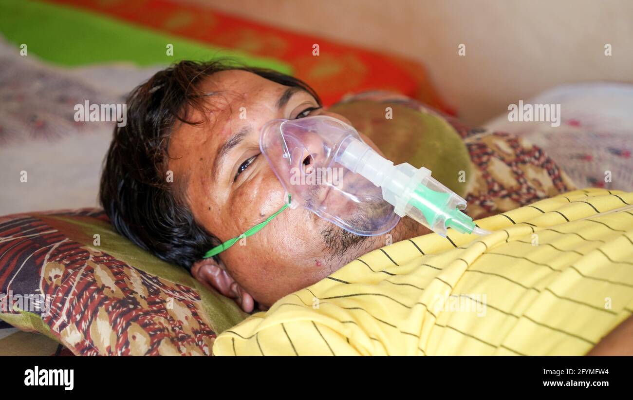 Jaipur, Indien - Mai 21: Nahaufnahme kranker Yong-Junge mit Gesichtssauerstoffmaske mit flüssigem Sauerstofffluss außerhalb des Krankenhauses. Junge infiziert mit Covid 19 Krankheit. Stockfoto