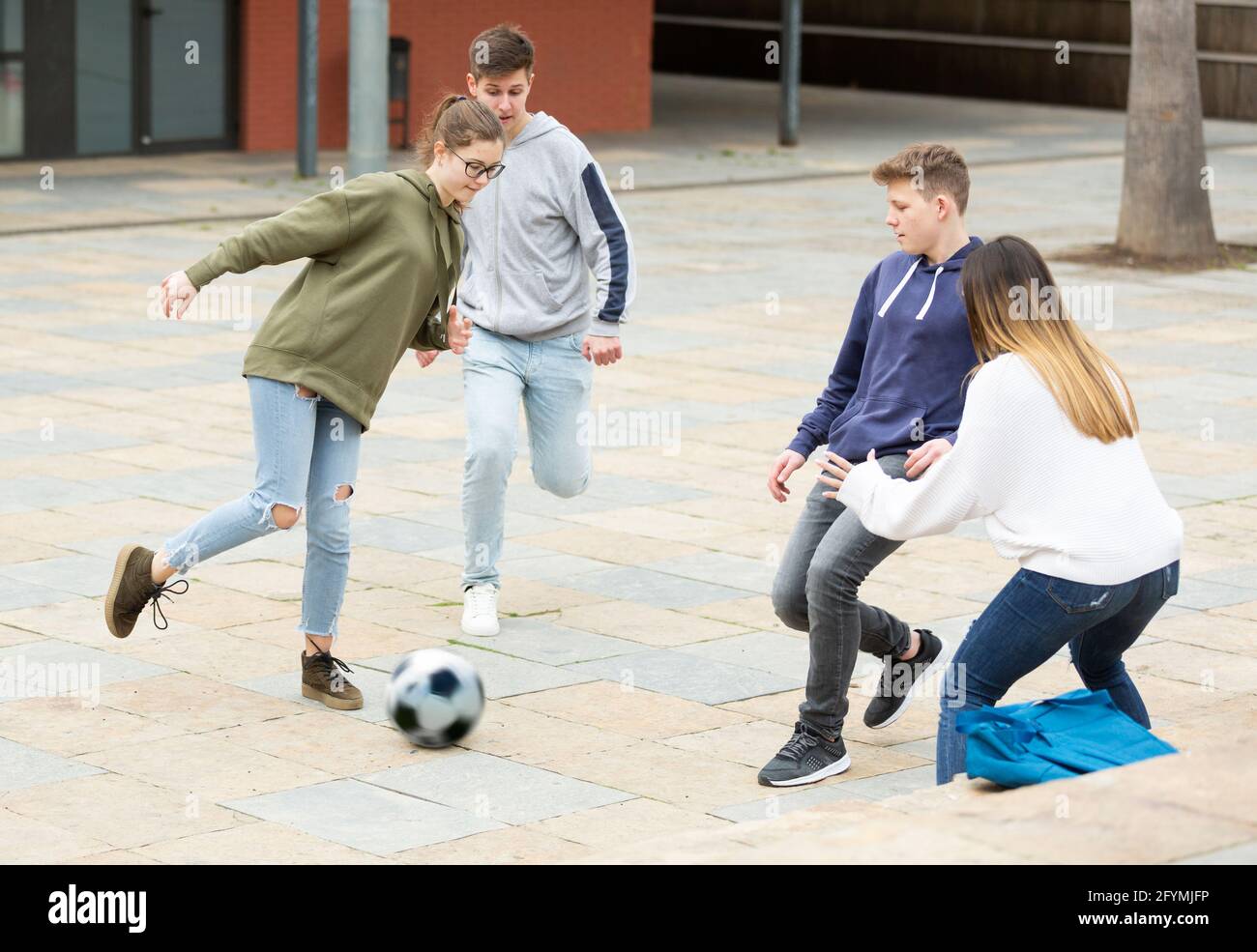 Gruppe von Teenagern, die im Freien Fußball spielen und Spaß haben Stockfoto
