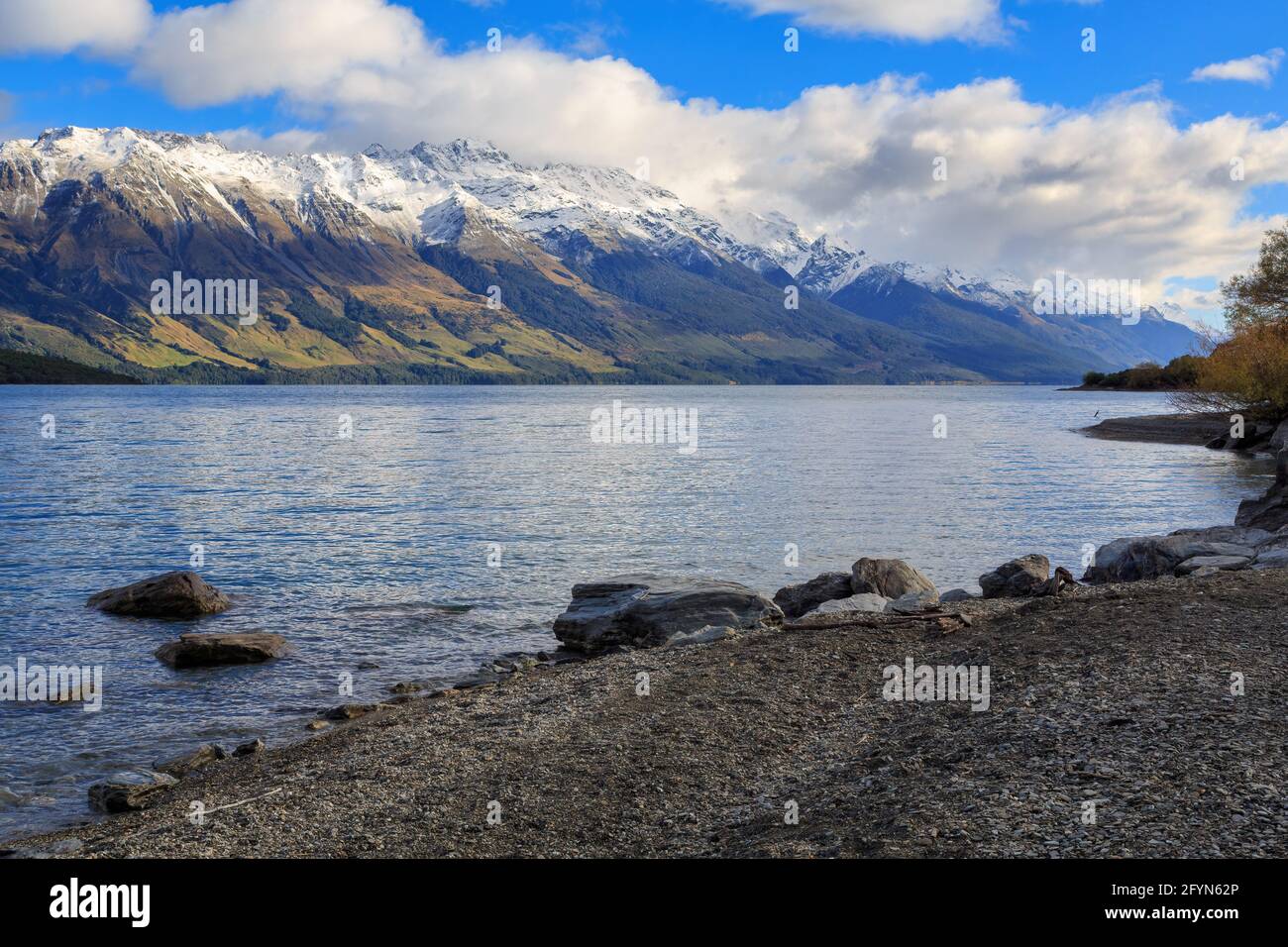 Lake Wakatipu auf der Südinsel Neuseelands. Ein felsiger Strand im Vordergrund, mit den Bergen der Südalpen am Horizont Stockfoto