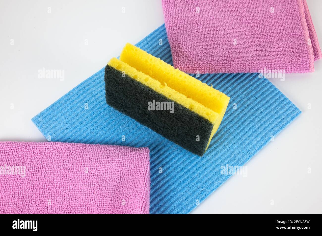 Geschirr und Hygieneartikel in der Küche: Schwamm, blaues Geschirrtuch und rosafarbenes Mikrofasertuch Stockfoto