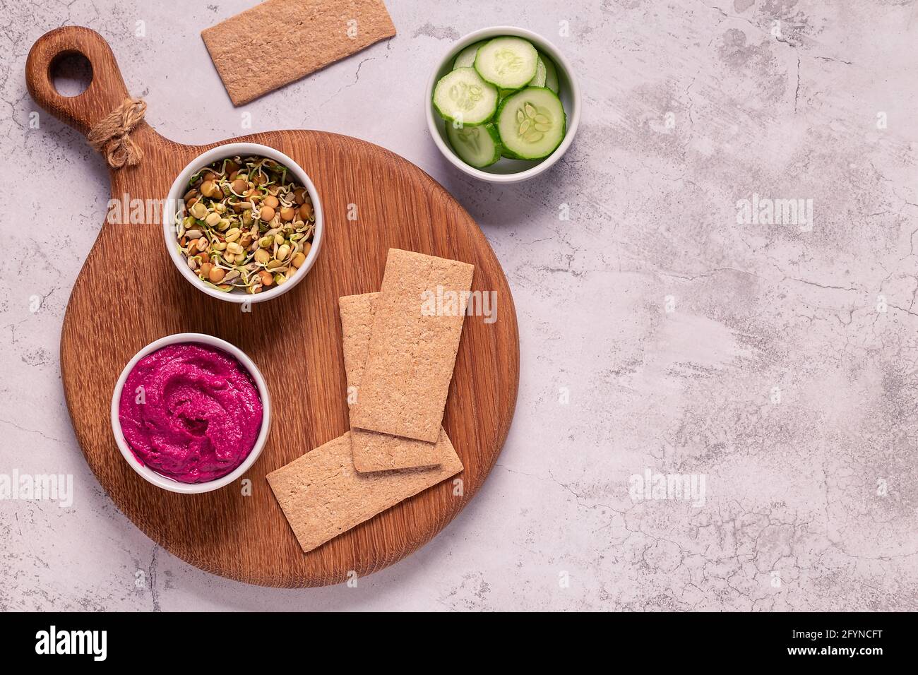 Vegetarischer, veganer Snack - Rote Beete Hummus, gekeimtes Getreide, Gurke und Vollkornknusprige. Stockfoto