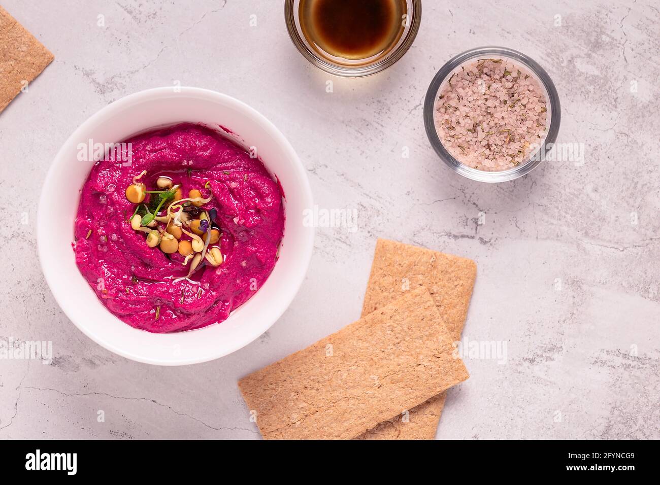 Gerösteter Rübenhummus mit gekeimtem Getreide und Knäckebrot, Draufsicht. Stockfoto